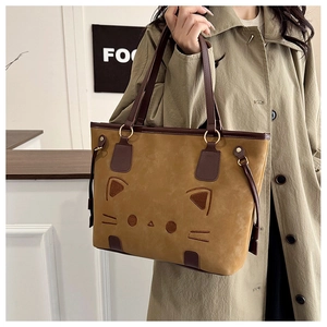 Détail du sac cabas marron clair avec broderie chat et bandoulières en cuir marron foncé