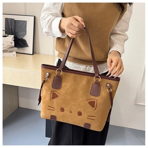 Close-up of khaki faux suede tote bag featuring cat face embroidery and dark brown handles
