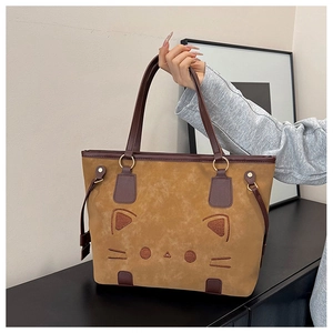 Détail de la broderie chat sur un sac cabas en daim avec anses en cuir café robustes