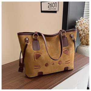 Détail du sac cabas kaki avec broderie visage de chat et lanières en cuir marron foncé