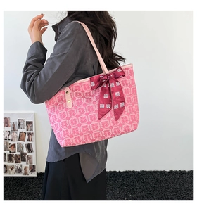 Pink canvas tote bag featuring red Xi patterns and decorative ribbon accessory