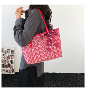 Detail of red festive pattern tote bag with decorative silk ribbon and bow handle