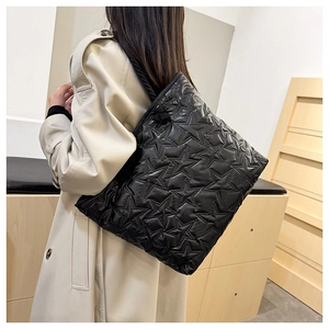 Detail of star-quilted black tote bag showing puffer nylon texture and rope strap