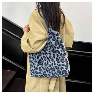 Detailed view of the gray-blue leopard faux fur tote bag on a model in a trench coat