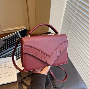 Burgundy lychee grain handbag with V-shaped sawtooth fringe and champagne gold hardware