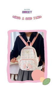 Detail of cute plaid backpack featuring heart prints and plush puppy embroidery