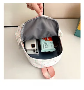 Interior storage view of a pink plaid backpack showing phone and accessory compartments