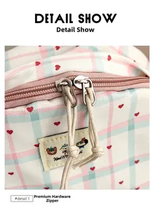Detail show of smooth metal double zippers with braided pulls on plaid school backpack