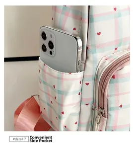 Side view of checkered school backpack featuring a convenient pocket for mobile phone storage