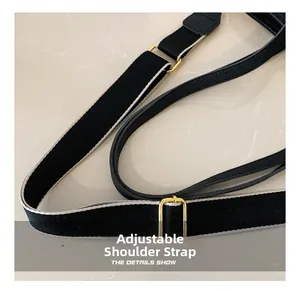 Détail de la bandoulière réglable en tissu noir avec boucle en métal doré chic
