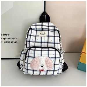 Detail of checkered school backpack featuring a cute 3D plush puppy patch and side pockets