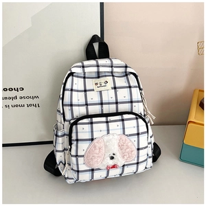 Detail of blue plaid school backpack with cute 3D plush dog patch and side pockets