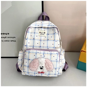 Detail view of the checkered school backpack showing the 3D plush puppy and purple strap