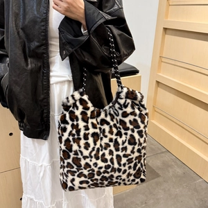 Chic leopard print plush tote bag with woven rope straps worn by a model in black leather