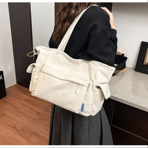 Dettaglio della borsa tote grande in velluto a coste con tasche laterali e trama fine