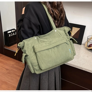 Dettaglio della borsa tote in velluto a coste verde con tasche e lacci gialli