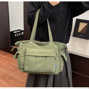 Dettaglio della borsa tote in velluto a coste verde oliva con tasca anteriore