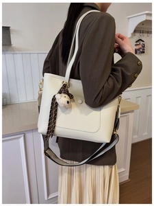 Détail du sac cabas en cuir litchi blanc avec bandoulière tissée et bijou d'ours