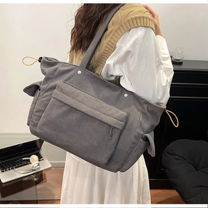 Dettaglio borsa tote in velluto a coste grigio scuro con tasche e coulisse gialla