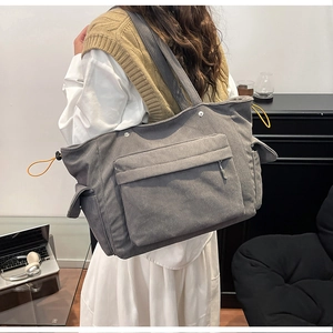 Dettaglio della borsa tote in velluto a coste grigio con tasche e lacci giallo brillante