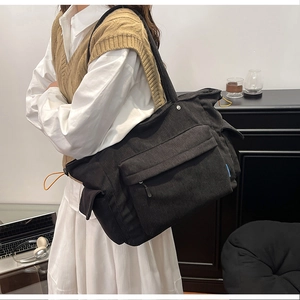 Dettaglio della borsa tote in velluto a coste nero con trama e cordoncino arancione