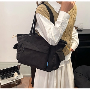 Dettaglio della borsa tote nera in velluto a coste con tasche e coulisse gialla vivace