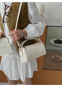Detail einer cremeweißen zylindrischen Boston-Tasche aus Leder mit Schultergurt