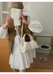 Vue détaillée d'un sac nuage en cuir blanc avec plis souples et fine bandoulière