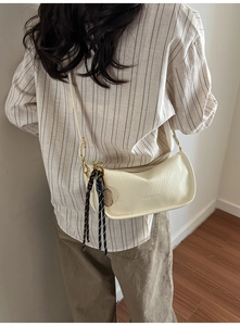 Detail of white PU leather crossbody bag featuring Fashion & Bag embossed logo text