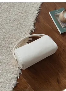 Schicke cremeweiße Zylindertasche mit Litschi-Textur auf dekorativem Vintage-Hintergrund