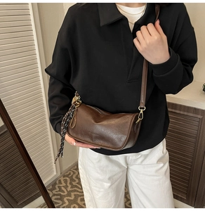 Close-up of brown retro crossbody bag with vintage leather texture and gold hardware