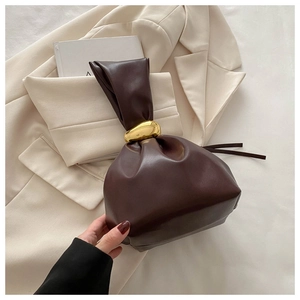 Détail du sac seau en cuir marron foncé avec boucle dorée et poignée froncée