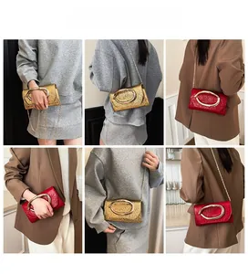 Detail showing high-quality lizard skin texture and large oval metal handle on crossbody bag
