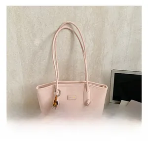 Detail of pink PU tote bag with elegant wood bead charm and branded metal nameplate