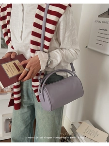 Detailansicht der lavendelfarbenen Leder-Zylindertasche mit rundem Griff und Gurt