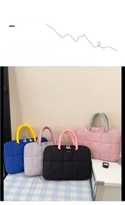 Multiple colorful quilted laptop bags with checkered texture and dual zippers on a desk
