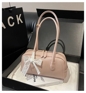Detail of light pink leather Boston bag with white lace bow on elegant gift box setting