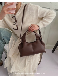 Détail de la texture litchi sur un sac cabas vintage en cuir marron foncé pour femme