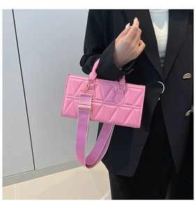 Pink rectangular crossbody bag with triangle quilting and wide fabric shoulder strap