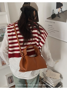 Sac à main en cuir caramel porté à l'épaule avec style rétro vintage et bandoulière fine