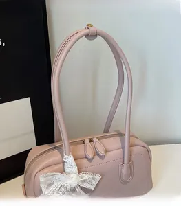 Détail du sac Boston en cuir rose poudré avec nœud en dentelle et double fermeture éclair