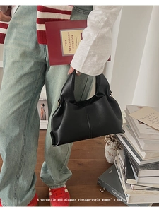 Détail de la texture cuir grainé noir du sac nuage avec boucle en métal doré