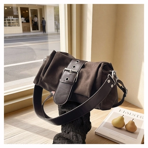 Gros plan détaillé d'un sac vintage marron foncé avec boucle et texture en daim doux