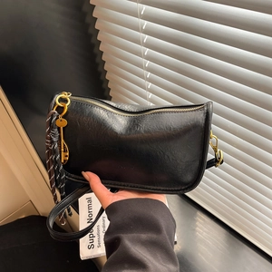 Retro black crossbody bag with textured leather, gold zipper and tennis racket charm