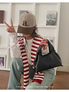 Détail d'un sac à main en cuir grainé noir dans un cadre de vie minimaliste