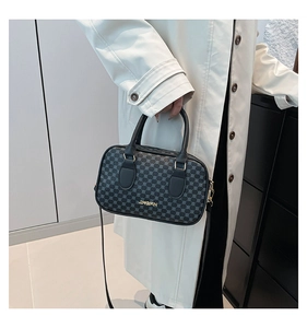 Detail of minimalist handbag with dot pattern and gold metal hardware on cream coat