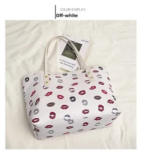 Detailed view of off-white tote bag featuring colorful lipstick prints and gold rivet details