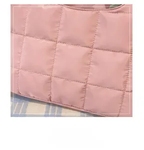 Close-up of pink quilted fabric texture and neat stitching on this padded laptop bag