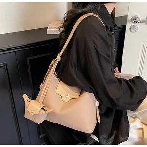 Detail of beige hobo shoulder bag with adjustable strap and matching mini coin purse