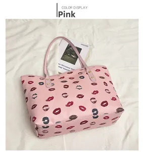 Detail of pink leather tote bag with red lip prints and golden rivet strap attachment
